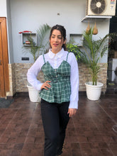 a woman wearing turquoise checked top with polo collar